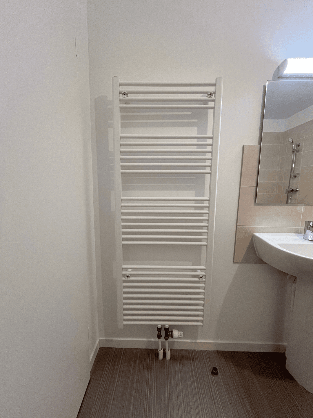 Sèche-serviette blanc installé dans la salle de bain  d'un logement neuf du projet Clésence à La Neuville-en-Hez  – LC THERMIC
