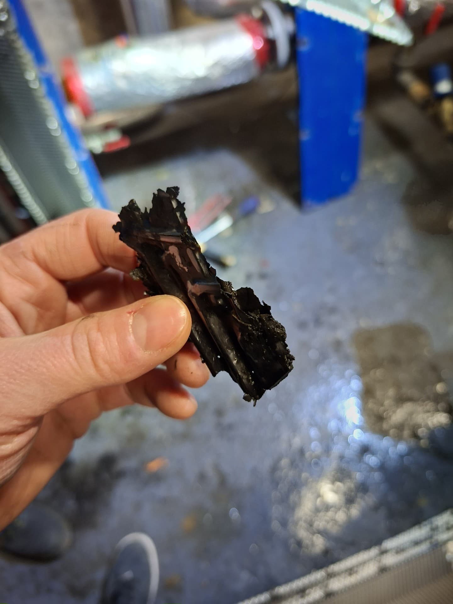 Technicien LC THERMIC tenant un bloc de dépôt de boue solide  extrait du réseau de chauffage d'une copropriété à Torcy  – preuve d'un réseau non entretenu