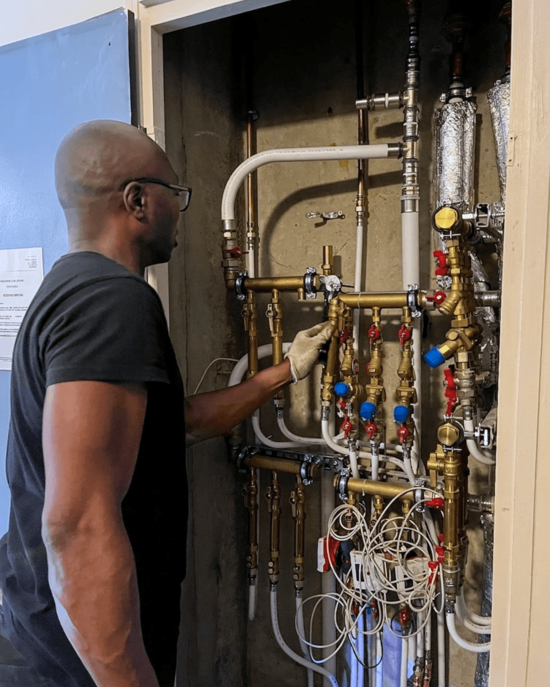 Technicien LC THERMIC installant les kits CIC dans une gaine palière  pour l'équilibrage logement par logement de la copropriété de Torcy