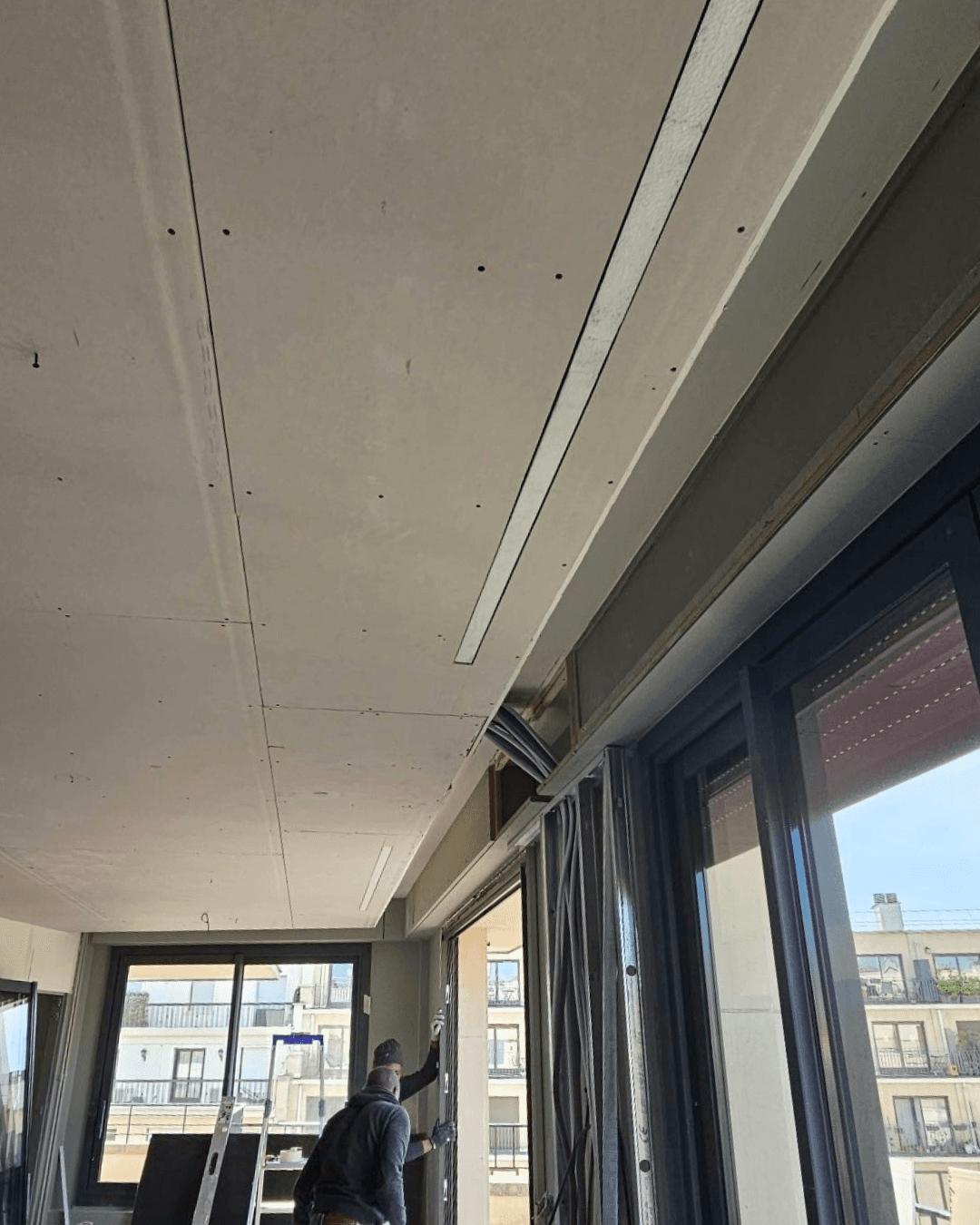 Installation climatisation gainable dans faux plafond – Paris – LC THERMIC Réseau de gaines aluminium pour climatisation réversible gainable dissimulé dans le faux plafond en cours d'installation à Paris par LC THERMIC