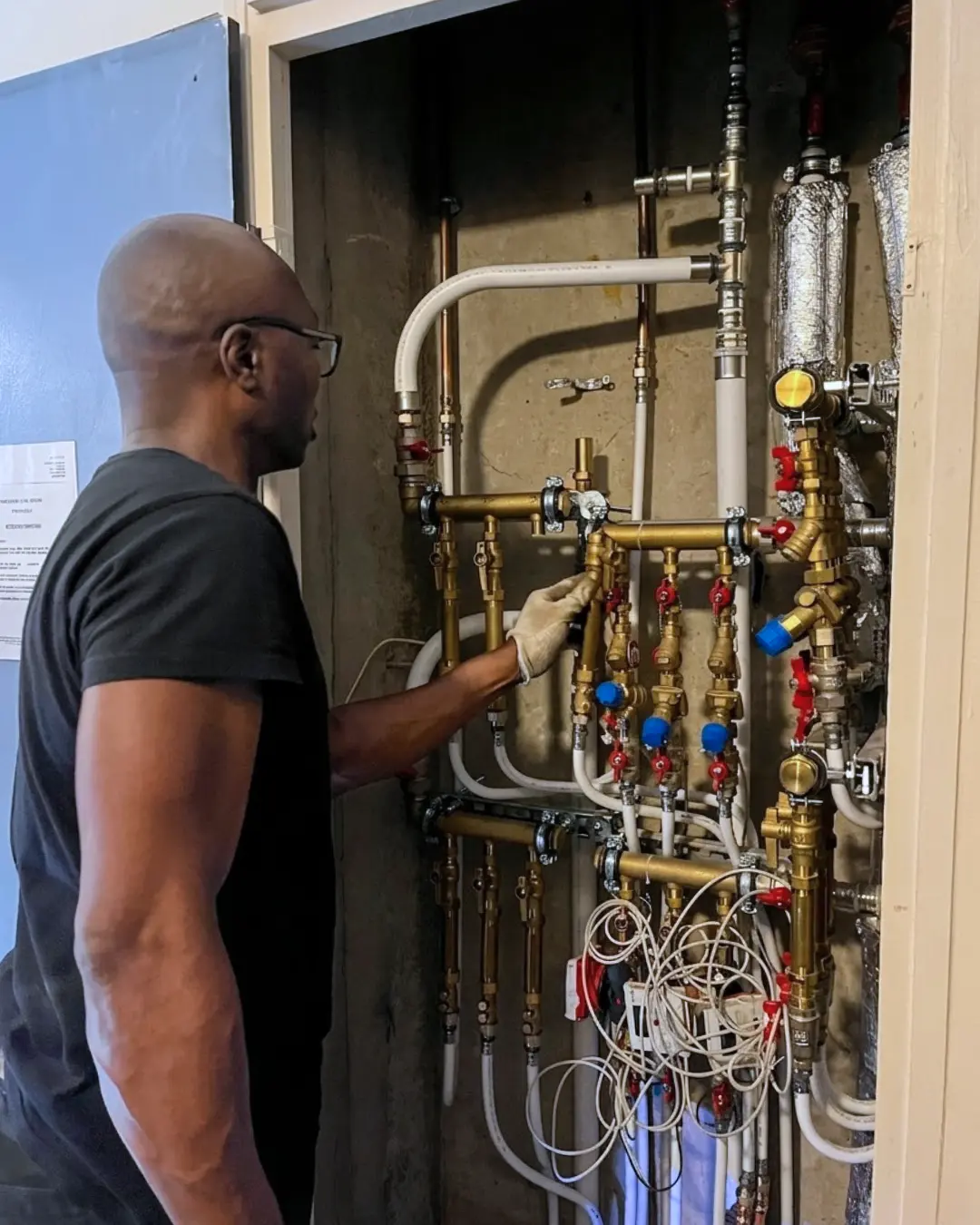 Installation kits CIC en gaine palière – Équilibrage logement par logement – Torcy Technicien LC THERMIC installant les kits CIC dans une gaine palière pour l'équilibrage logement par logement de la copropriété de Torcy